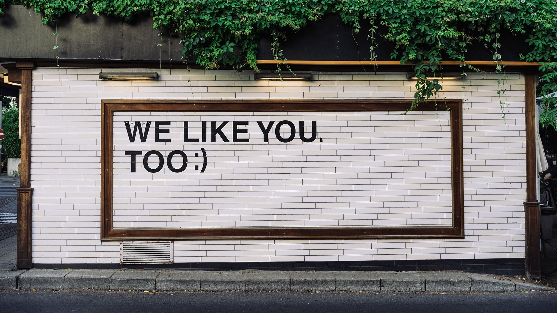 représentation de l'intéret des réseaux sociaux pour le seo par le message we like you too sur un mur